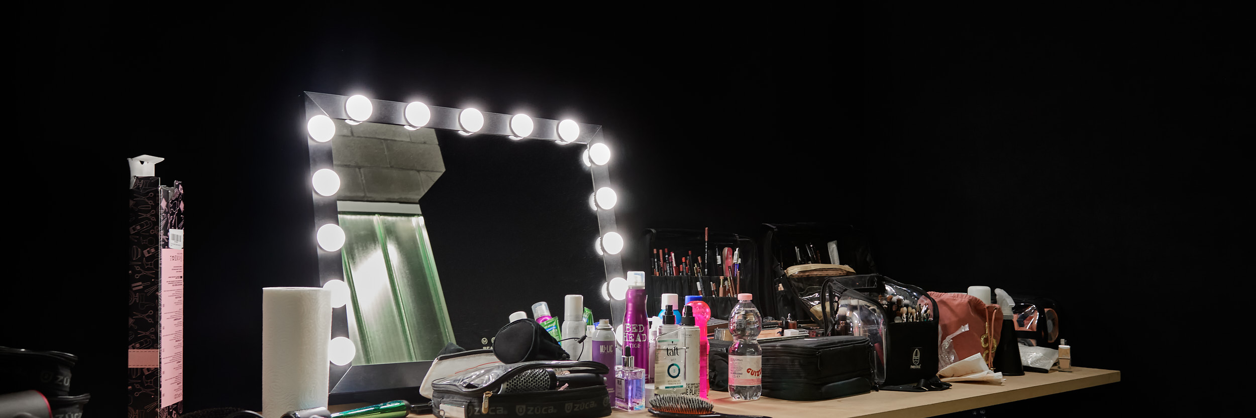 LCBstudio - area make-up con tavoli, specchio con luci e prodotti